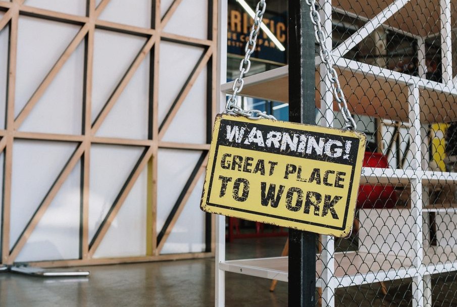 Humorous warning sign in a modern industrial loft workspace, capturing a blend of creativity and humor
